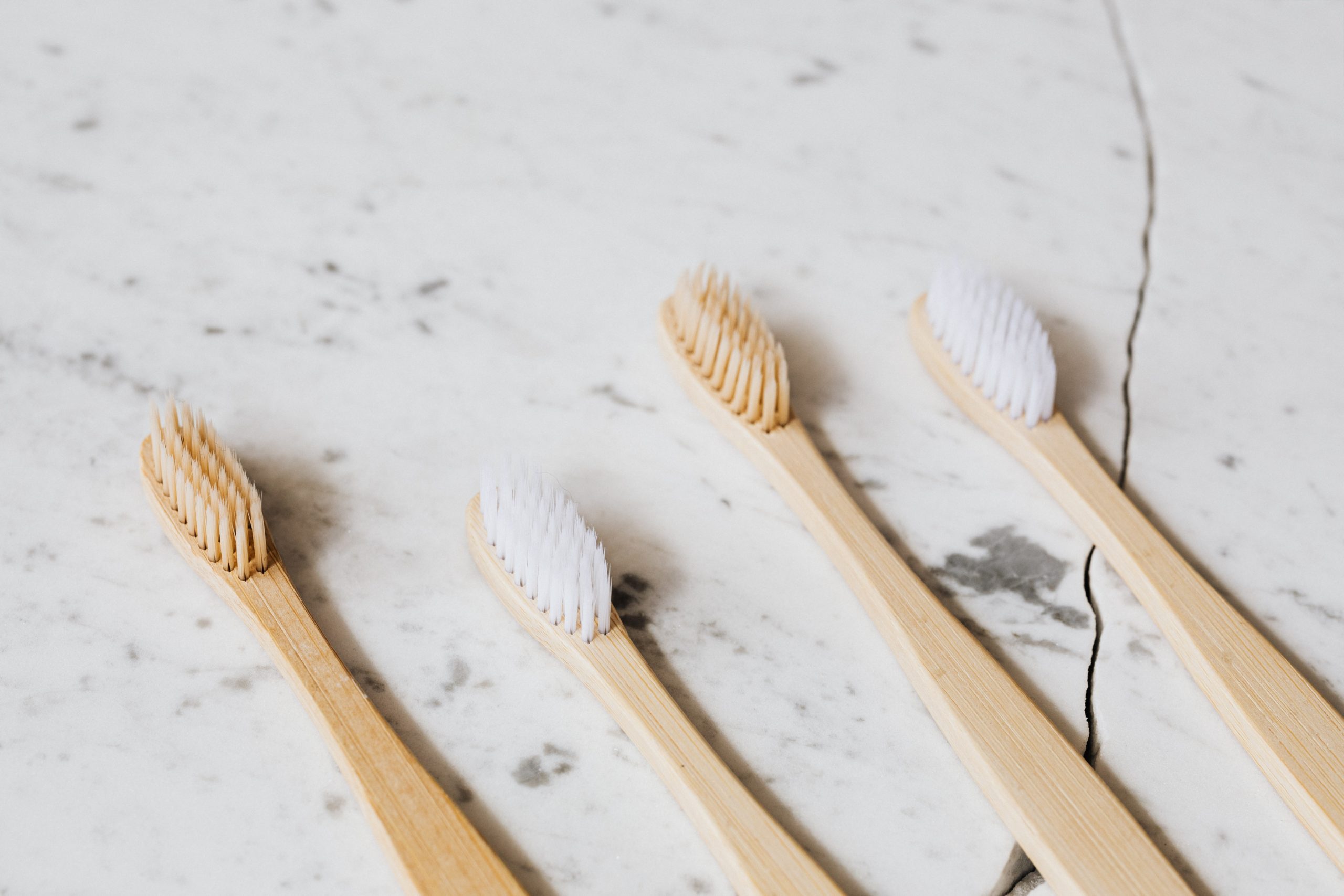 Four Toothbrush on White Surface by Karolina Grabowska
